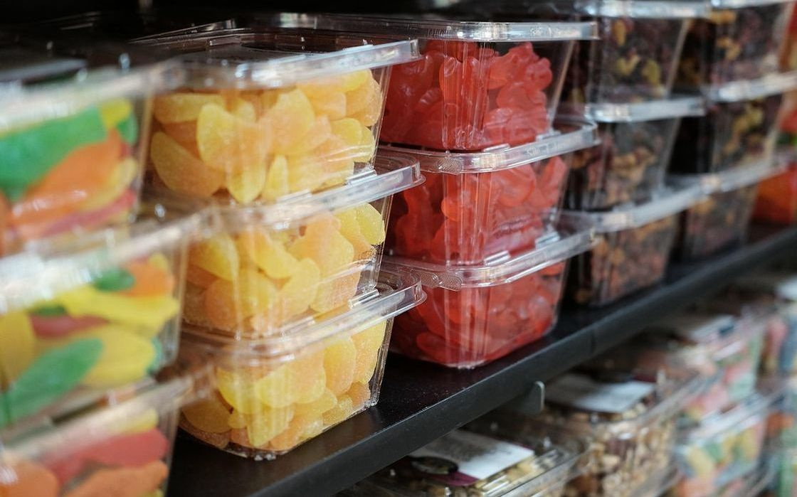 The shop frontage on a sunny corner, window display filled with colourful sweets and chocolate bonbons